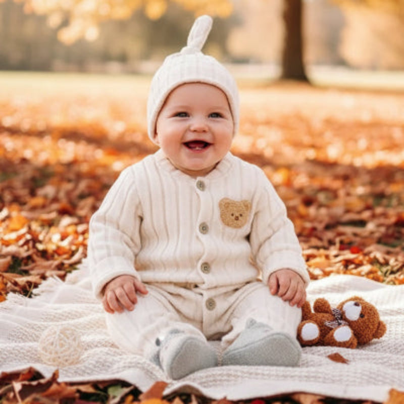 Bébé dans feuilles avec combinaison bebe ours softy nuage