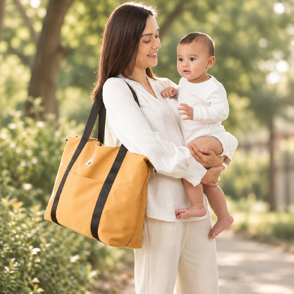 Femme-porte-sac-a-langer-décontracté-sur-une-épaule-et-bébé-dans-ses-bras