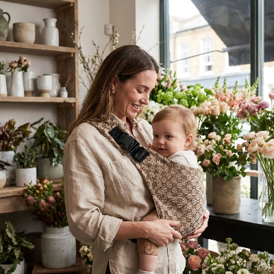 Mère chez fleuriste et écharpe de portage physiologique hanche