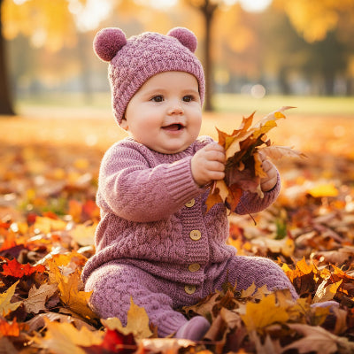 Bébé joue dans feuilles avec combinaison chaude bebe cocon cozy rose