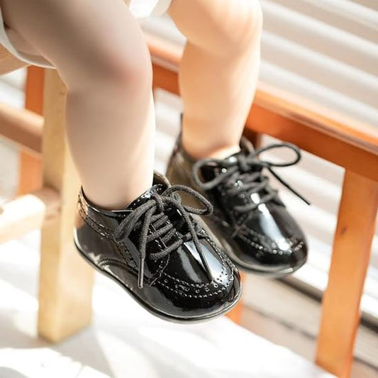 Enfant assis avec chaussure bebe premiers pas noir