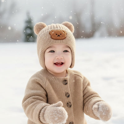 Enfant joue dans neige avec bonnet bebe ourson confort
