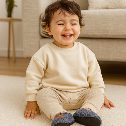 Garçon rit avec chaussons bébé antidérapants