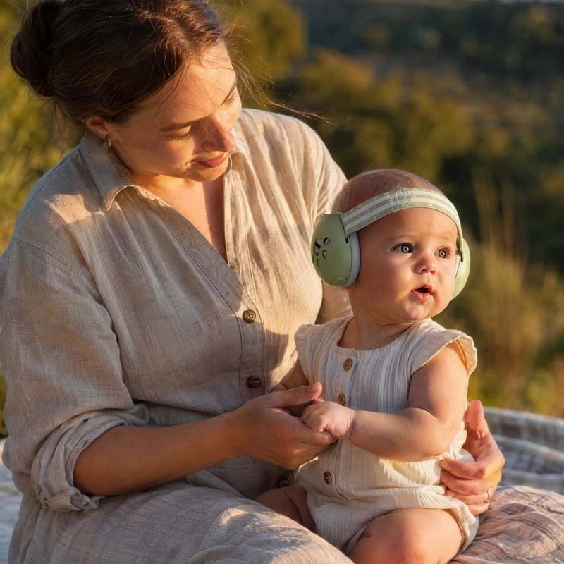 Mère avec bébé dans casque anti-bruit bébé cocon protecteur vert
