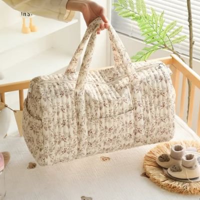 Mère dépose sac a langer fleuri dans lit bébé