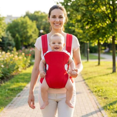 Mère marche dans parc avec porte bébé douillet