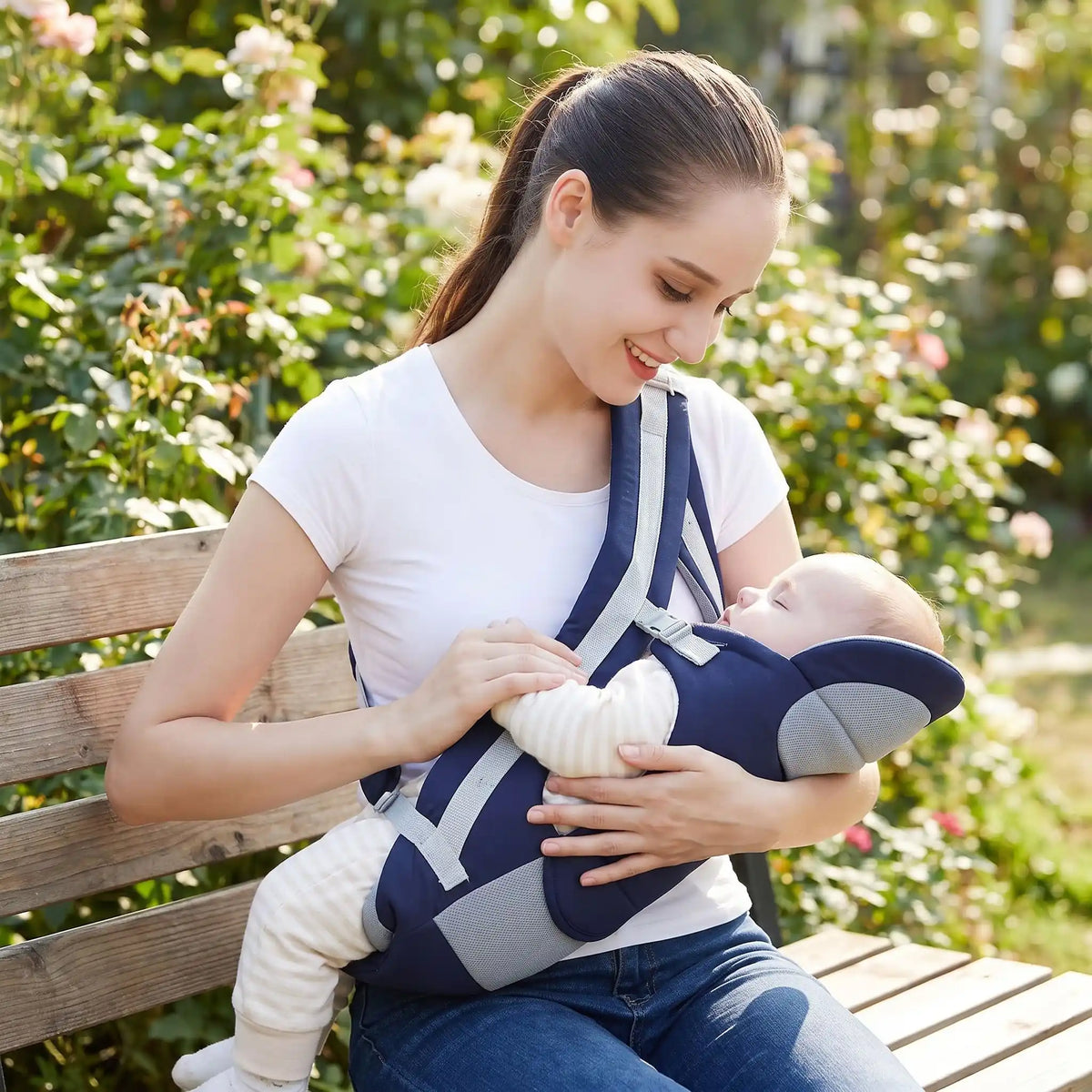 Porte bébé physiologique bleu foncé dans beau jardin