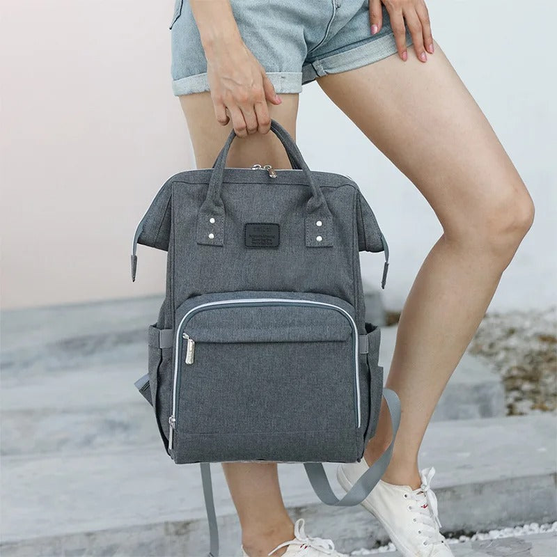 sac à dos à langer convivial gris foncé dans main